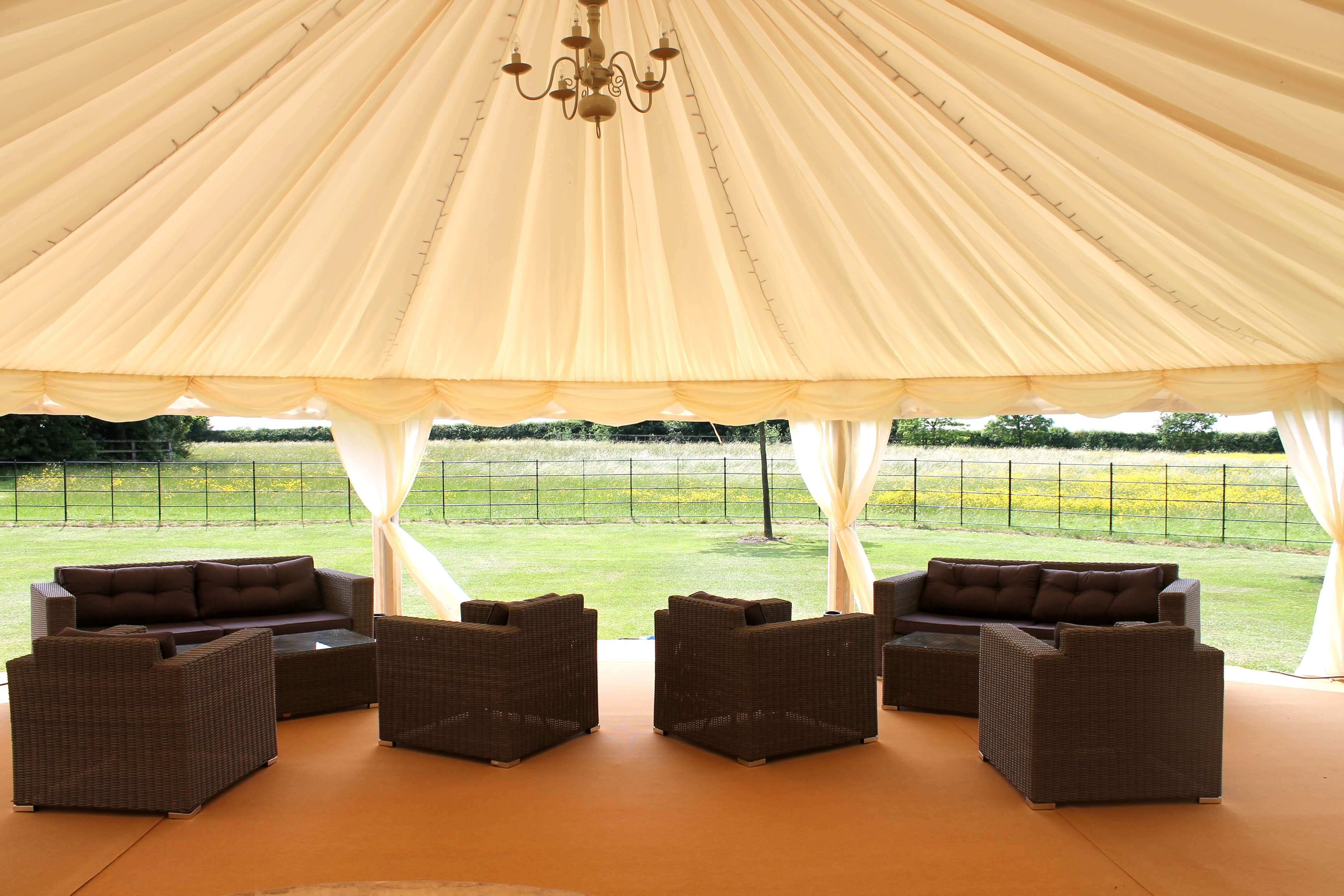 comfortable chairs inside marquee looking out onto fields